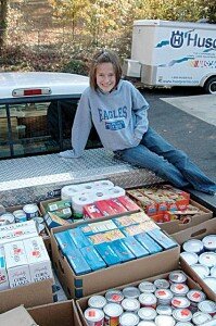 Grace at age 8 with some of the food she collected for needy families