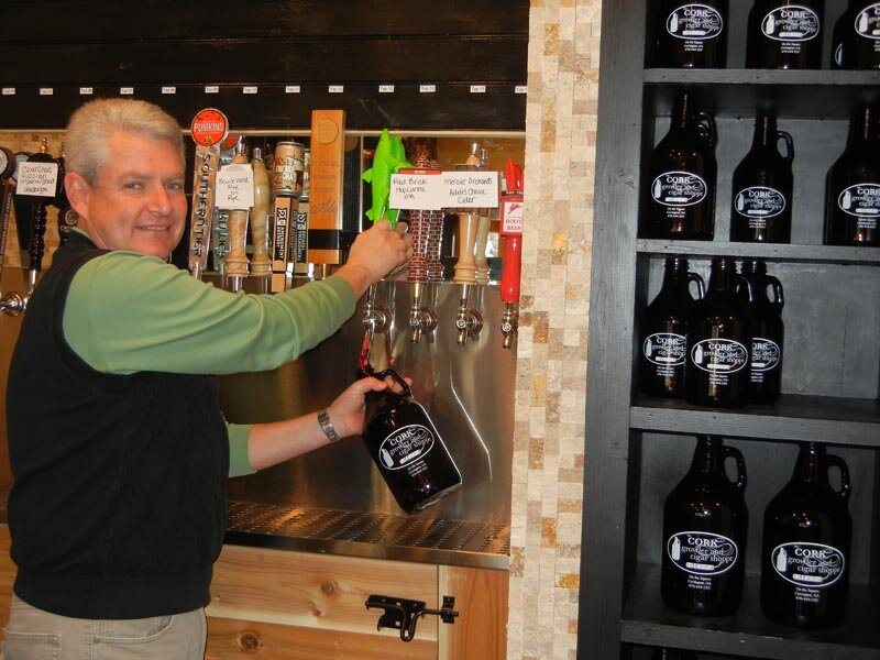 Co-Owner Jack Phillips pouring a growler at the CORK growler and cigar shoppe. The growler shoppe features 16 taps for customers to fill their growler jugs with and take home.